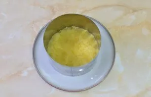 We will lay out the salad in layers. Place the serving ring on a plate. As the first layer, put grated potatoes. Coat this layer and all ...