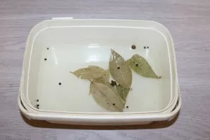 In the container where you will salt the herring, mix water, salt, sugar, vinegar, pepper and bay leaf.