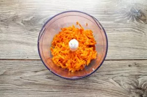 Peel the carrots and grate on a coarse grater, put in a blender bowl with fish.