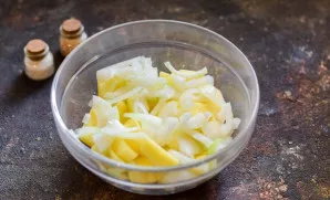 Peel the onions, cut them into half rings and add them to the potatoes.