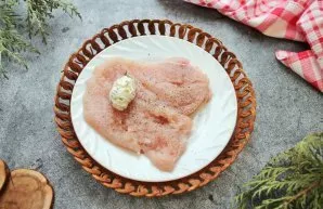 Mix soft butter with chopped herbs and make two sausages. Put each on top of the chicken pieces.