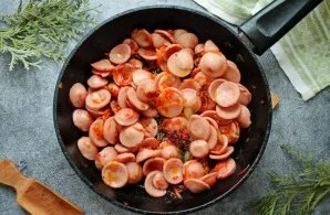 Peel the sausages and cut into slices. We put the sausages in a pan with vegetables and, stirring everything, fry for 3-4 minutes.