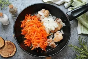 Reduce the heat to medium, add chopped onions and grated carrots to the chicken. Cook for 5 minutes, stirring.