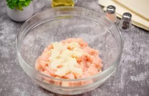 Peel onions and garlic, grate on a fine grater and add to the chicken.