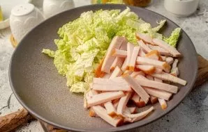 Cut the smoked chicken fillet into thin strips. Add to cabbage.