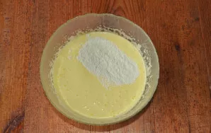 In small portions, add the sifted flour.