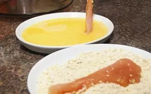 Cut the chicken fillet into thin long strips. Dip the chicken pieces first in the eggs, and then roll them in breadcrumbs.