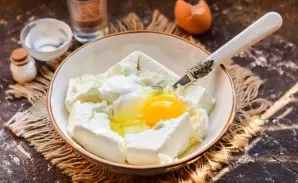 Beat an egg and a portion of sour cream into the cottage cheese.