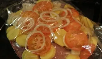 Lay out tomatoes and onion rings on top of the potatoes.