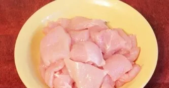 Now cut the chicken fillet into pieces about 3 centimeters in size, then salt and sprinkle with ground pepper.