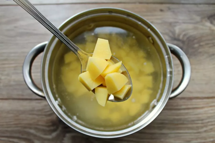 Peel the potatoes and cut them into cubes. Add the potatoes to the broth and cook over medium heat for 15 minutes.