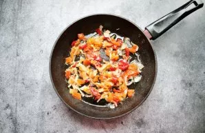 Clean the peppers, cut into cubes and add to the onion, mix.
