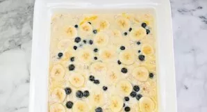 Beat the eggs with milk and melted butter and carefully evenly pour the mixture over the oatmeal. Put the remaining bananas and blueberri...