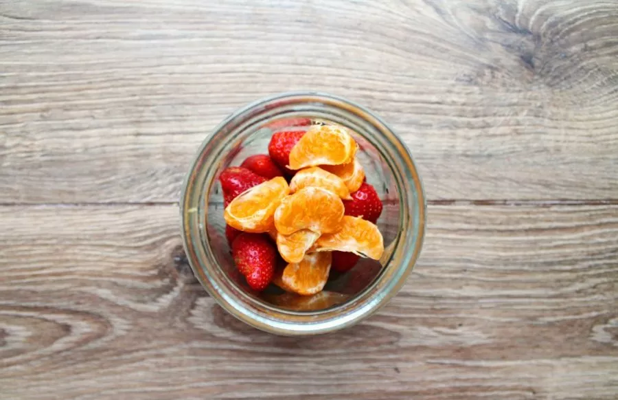 Peel the tangerine from the peel and white veins. Cut into slices, remove the seeds and place in a jar.