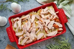 Remove bones and skin from the chicken, cut into pieces and put on top of the potatoes.