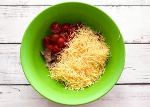 Grate the cheese on a fine grater and add it to the plate with the ham and tomatoes.