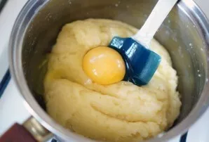 Beat the egg and continue kneading the dough.