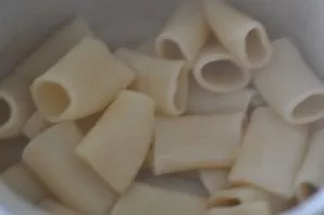 We cook the pasta to half. Drain in a colander, pour vegetable oil and mix.