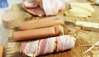 Wrap each sausage with a strip of bacon.