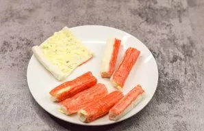 Unwrap the crab sticks and coat with cheese filling. Then roll them back into tubes.