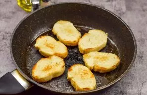 Heat olive oil in a pan, add slices of baguette and fry on both sides for a few minutes.