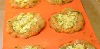 In the minced meat, make recesses and put the filling in them.