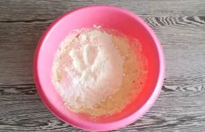 Add 160 grams of flour and baking powder. Start stirring with a spoon.