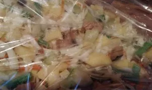 Evenly distribute all the vegetables in the sleeve. Tie the sleeve on one side, then insert the fish and tie the sleeve on the other side.