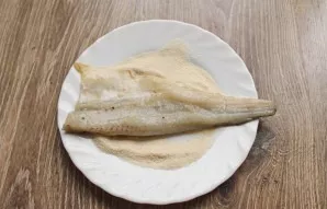 Pour the semolina into the container and roll the fish in the semolina.
