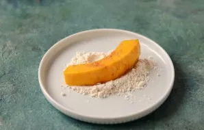 Roll the pumpkin pieces in flour.