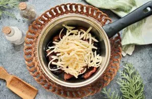 Add 2/3 of the grated cheese to the cooled dried fruit and mix.