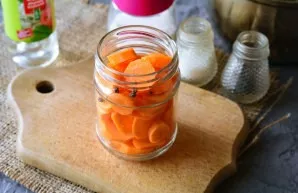 Put carrots and peppers in a sterilized jar.