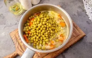 Add canned green peas and garlic, boil the vegetables for another 5-7 minutes.