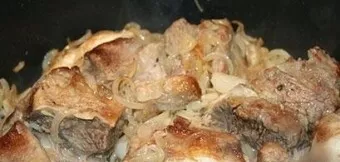 Add the onion to the pan with ribs, mix everything and simmer further.