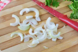 Peel the onion and cut into thin half rings.