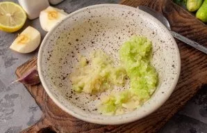 Grate the peeled garlic to the apple with the cucumber or squeeze it through a press.