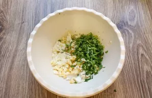 Finely chop the greens and put in a bowl with an egg.