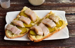 Lay out pieces of herring on the cucumber.