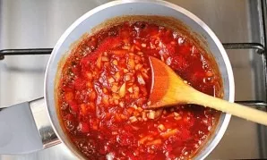 Place the pot on the stove, and when the sauce boils, simmer until the onions soften.