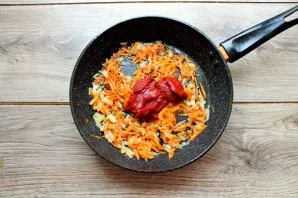 Pour tomato paste into the pan, stir and fry for another minute.
