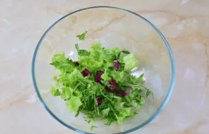 Tear lettuce leaves and rukol with your hands into a salad bowl.