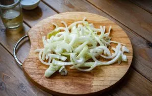 Cut the peeled onion into thin half rings.