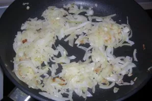 While the dough rises, we will make the filling. Pour vegetable oil into the pan and fry the finely chopped onion until golden brown.