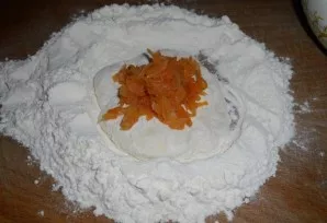 We form a pancake from the dough, add a little flour and put the filling in the middle.