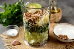 Add grated Parmesan, chopped nuts and garlic. Add a pinch of salt, pour oil.