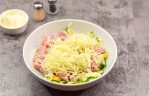 Grate the hard cheese. Transfer the cheese to the salad.