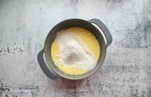 Mix flour with baking powder and sift. Pour in parts into the egg mixture and stir gently until the dough becomes homogeneous without lumps.