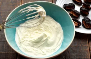 Add powdered sugar to the heavy cream, beat the mixture until you get a stable and fluffy mass.