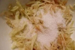 Wash and peel the apples, remove the seeds, grate on a coarse grater, add 50 grams of granulated sugar.