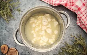 Slowly pour the broth into a saucepan, stirring all the time. Add cauliflower inflorescences to the soup.